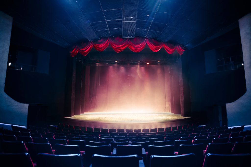 Empty auditorium with brightly lit stage.