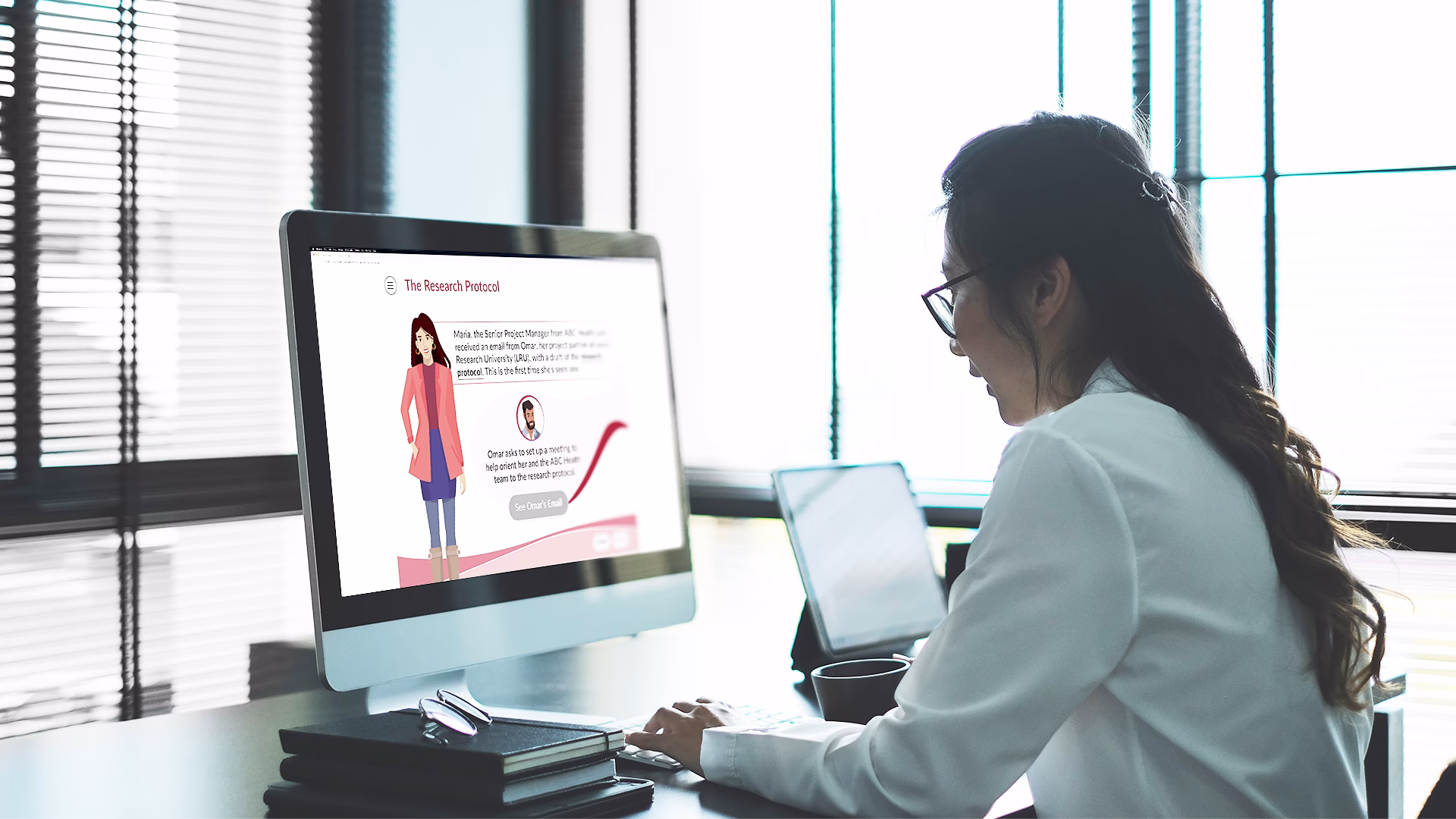 Woman sitting in front of a computer in a dimly lit room, working through eLearning module designed by Brella Productions.