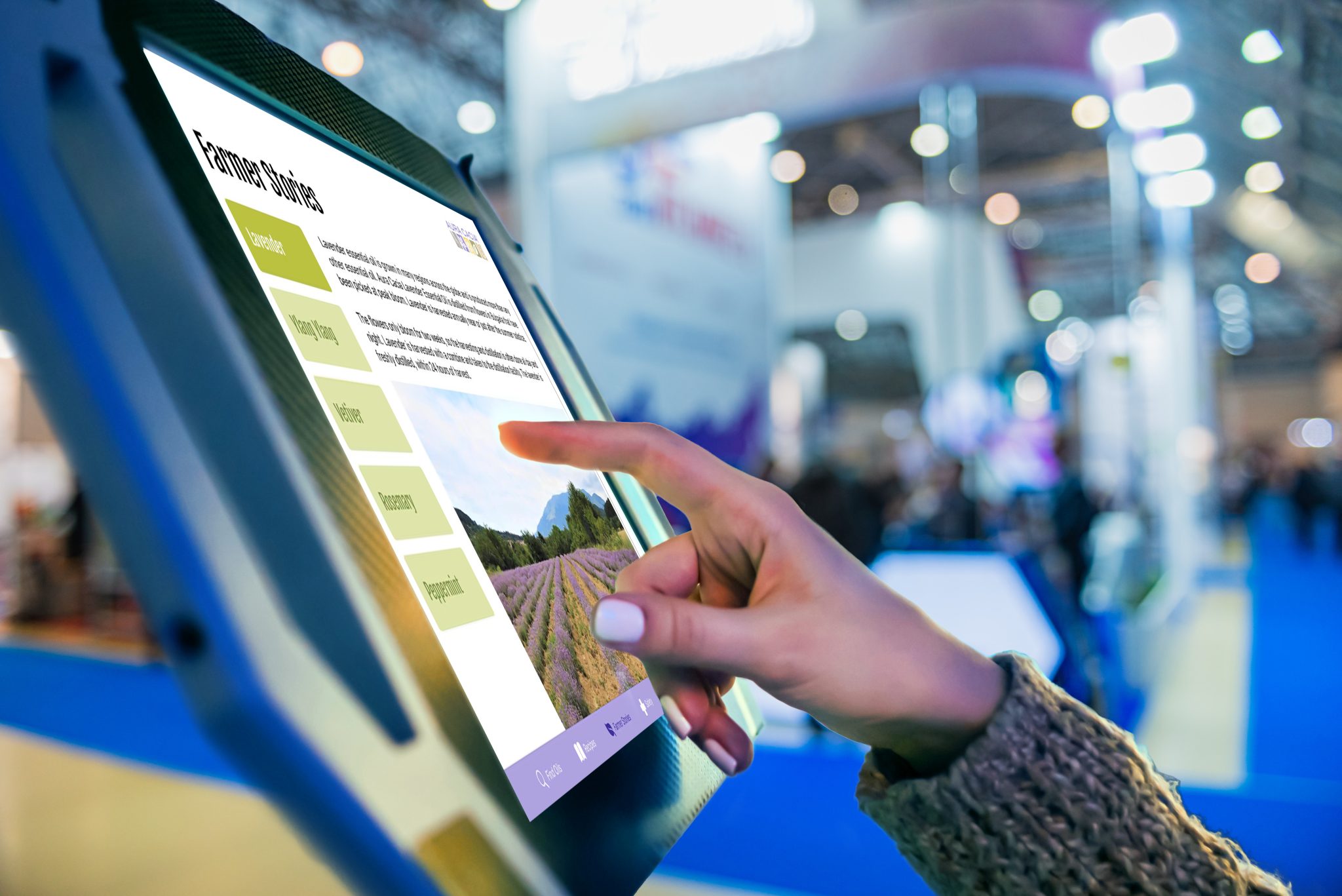 Closeup of a woman's hand tapping a touchscreen display on farming at a tradeshow.